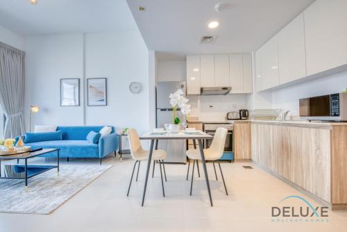 a kitchen and living room with a table and chairs at Chic 1BR in Town Square UNA Dubailand by Deluxe Holiday Homes in Dubai
