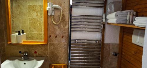 a bathroom with a sink and a shower with towels at Swiss Eviniz Hotel in Adrasan