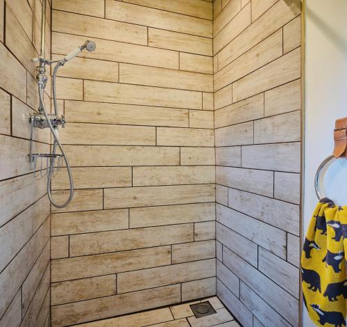 y baño con ducha y paredes de madera. en Great Lilly Cottage, en Barnstaple