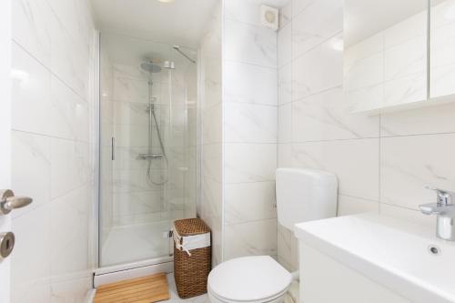 a white bathroom with a shower and a toilet at Villa Liva in Vantačići