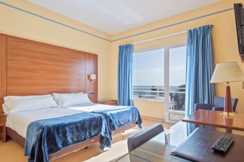 a hotel room with a bed and a desk and a window at Hotel Sant Jordi in Tarragona