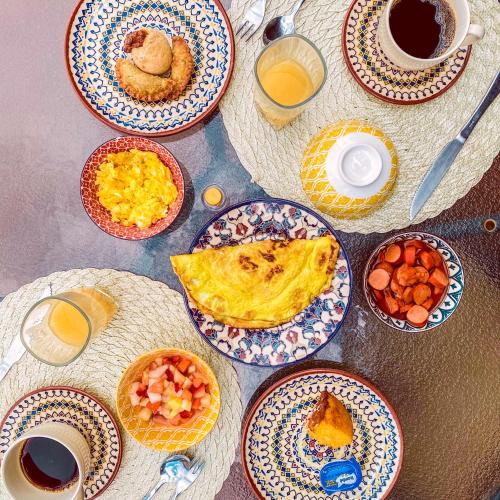 a table with plates of food and cups of coffee at Pousada Quintal da Lua in Capitólio