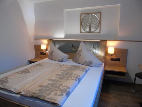 a bedroom with a large bed with a blue bedspread at Pension Sonnleitner in Heiligenblut