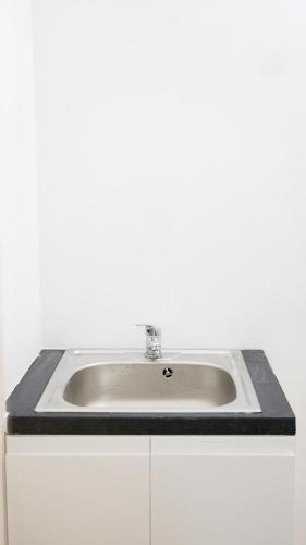 a bathroom sink with a black counter top at Abingdon Lodge & Suit in Ryde