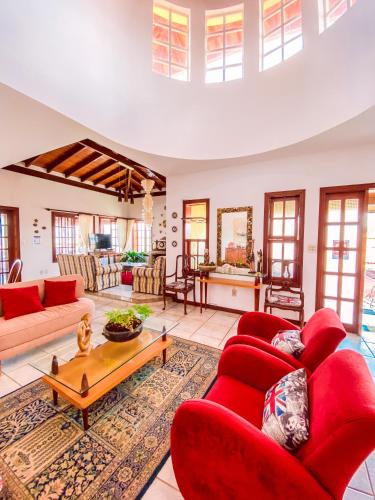a living room with red couches and a table at Pousada Quintal da Lua in Capitólio