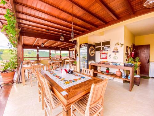 a dining room with a wooden table and chairs at Pousada Quintal da Lua in Capitólio