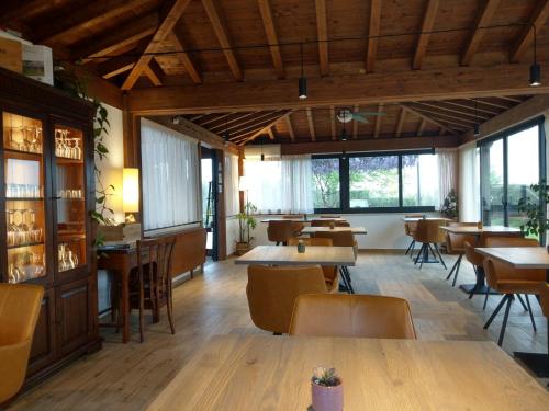 un restaurante con mesas, sillas y ventanas en Agriturismo Il Cavallino Saturnia en Semproniano