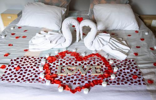 a bed with two swans making a heart with the word love at La case Maui in La Saline les Bains
