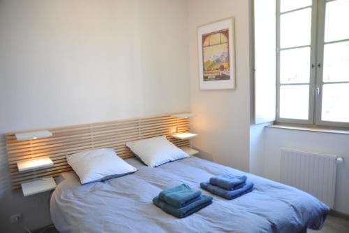 une chambre avec un lit avec deux serviettes dessus dans l'établissement Résidence BAVARA, à Luchon