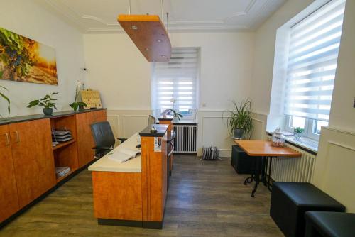 an office with a desk and a table and windows at Hotel & Restaurant Tanne in Fischingen