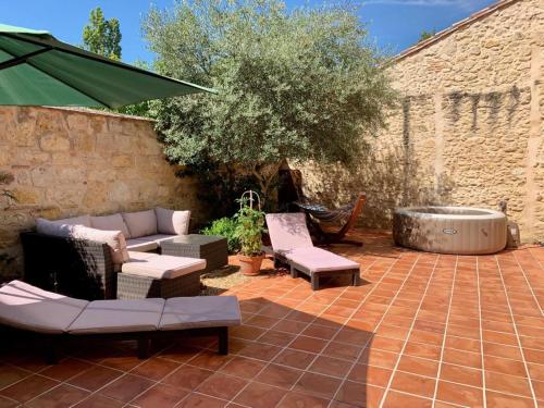 a patio with a couch and chairs and a hot tub at '1786' au bourg in Mansonville