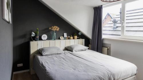 a bedroom with a bed and a window at HuisjehurenEgmond in Egmond aan Zee