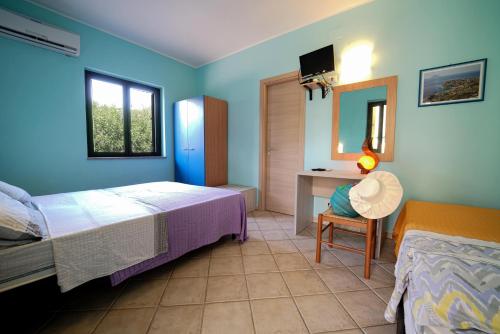 a bedroom with a bed and a desk with a mirror at casa vacanze margherita in Capo Vaticano