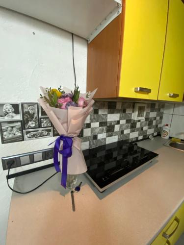 a bouquet of flowers in a vase on a kitchen counter at House&House 84 in Petropavlovskaya Borshchagovka