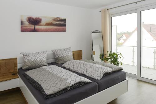 a bedroom with a bed with a picture on the wall at Ferienwohnung Schertel in Pleinfeld
