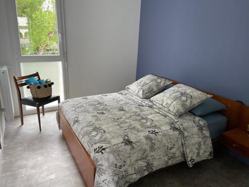 1 dormitorio con 1 cama, 1 silla y 1 ventana en Chez Charlotte, en Périgueux