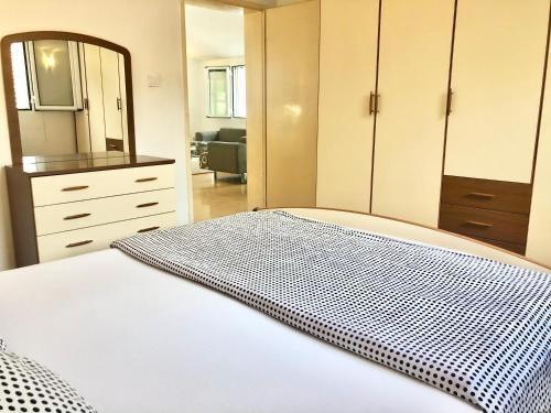 a bedroom with a bed and a dresser and a mirror at House with big terrace and beautiful sea view in Kotor