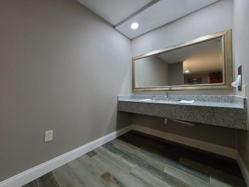 a bathroom with a sink and a mirror at Scottish Inns & Suites in Springdale