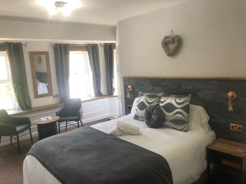 a bedroom with a large bed and two chairs at Alpine Lodge Guest House in Llanberis
