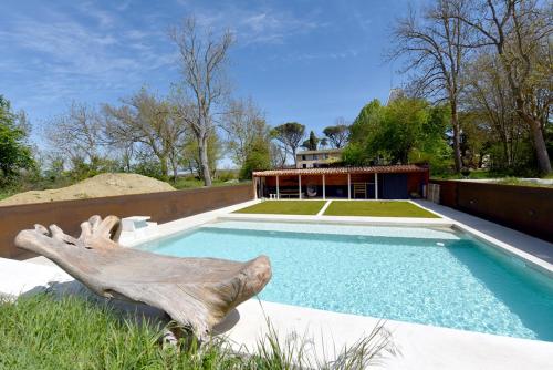 une statue d'un poisson à côté d'une piscine dans l'établissement la serre d Embarthe, à La Pomarède