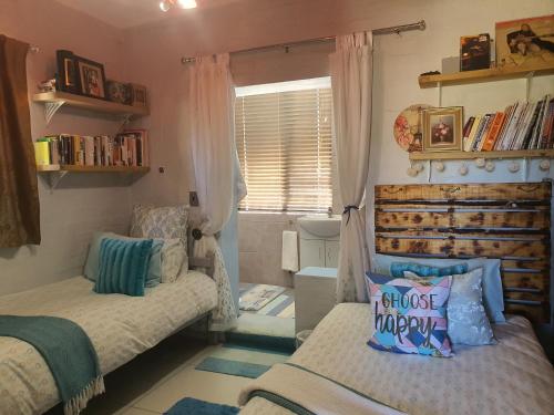 a small bedroom with two beds and a window at Clanwilliam Hills House in Clanwilliam