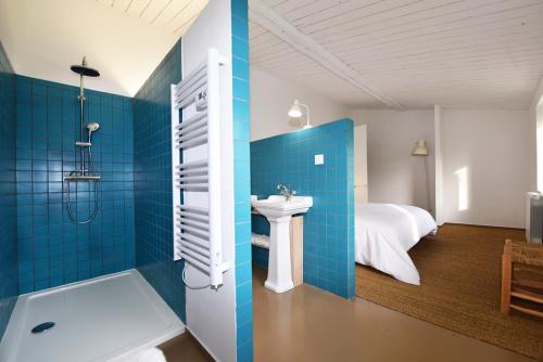 une salle de bain avec un lavabo et une douche et un lit dans l'établissement la serre d Embarthe, à La Pomarède