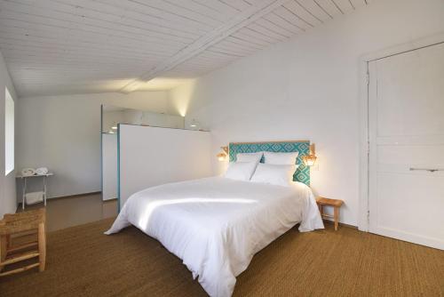 1 dormitorio con cama blanca grande y pizarra en la serre d Embarthe en La Pomarède