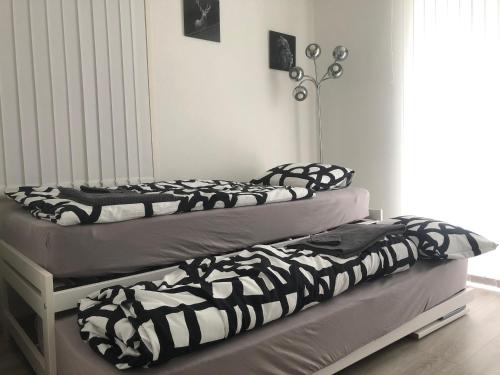 two beds in a room with black and white blankets at Les Dents-du-Midi in Monthey