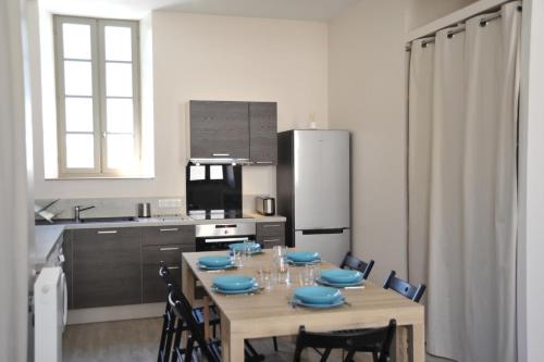 une cuisine avec une table avec de la vaisselle bleue dessus dans l'établissement Résidence BAVARA, à Luchon