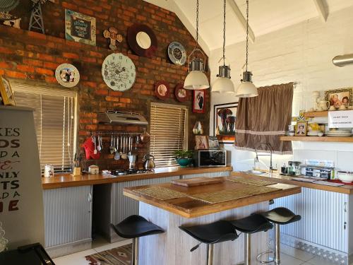 a kitchen with a counter with stools in it at Clanwilliam Hills House in Clanwilliam