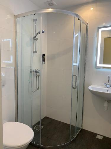 a bathroom with a shower and a toilet and a sink at Orange Tulip Hotel in Amsterdam
