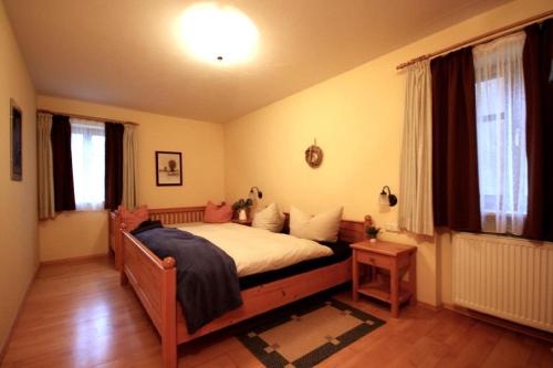 ein Schlafzimmer mit einem großen Bett in einem Zimmer in der Unterkunft Landhof Fischer in Geiersthal