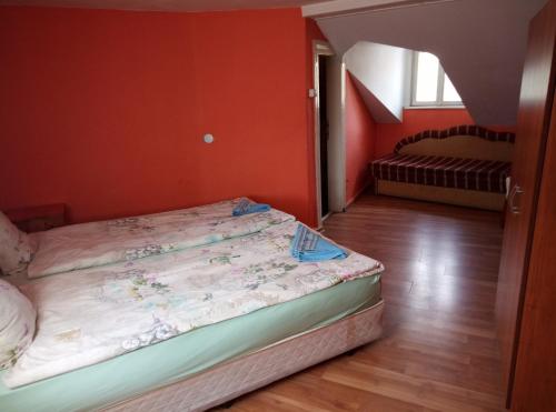 a bedroom with two beds in a room with orange walls at Casablanca City in Varna City