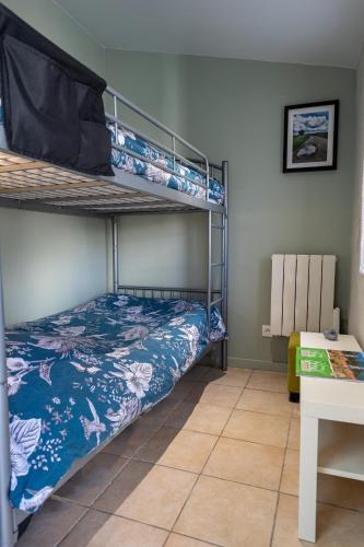 une chambre avec un lit superposé et un bureau dans l'établissement Petit gite du Bistrot d ici, à Saint-Saturnin
