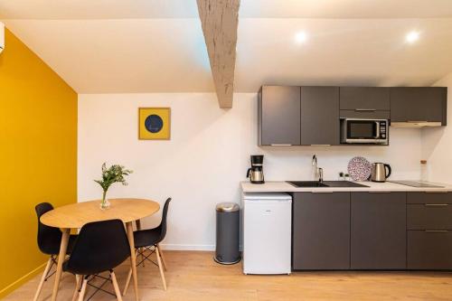 une cuisine avec une table en bois et une table et des chaises dans l'établissement SUNNY - T2 CENTRE HISTORIQUE, à Agen