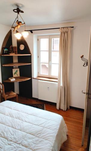 une chambre avec un lit et une fenêtre dans l'établissement La Maison de Caroline, à Westhoffen