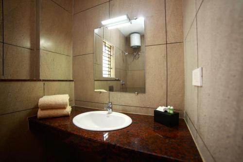 a bathroom with a sink and a mirror at ABI`S RESIDENCY in Thanjāvūr
