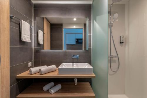 y baño con lavabo y ducha. en Lagrange Apart'Hôtel Antibes Olympie, en Antibes