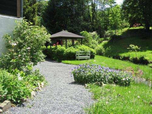 a gravel path with a gazebo in a garden at Vakantiehuis ibu in Altenau