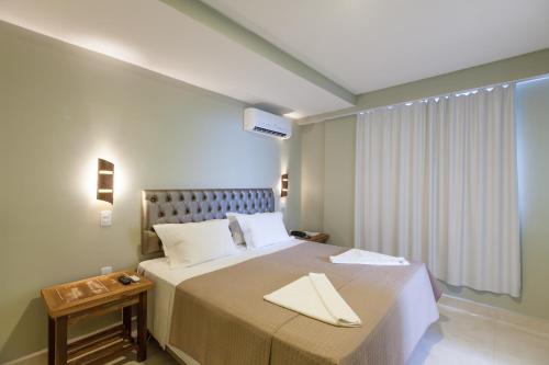 a bedroom with a large bed and a window at Pousada Castellammare in Bombinhas