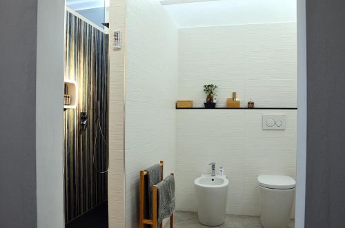 a white bathroom with a toilet and a sink at BB Borgo Biella in Candelo
