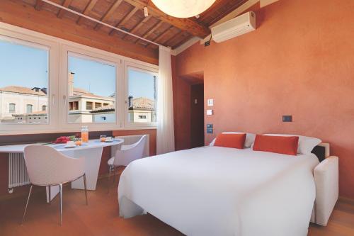 a bedroom with a large white bed and a table at 1881 LUXURY SUITES in Verona