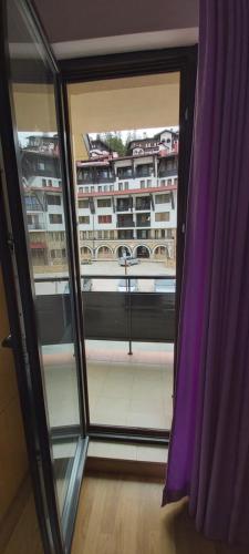 a window with a purple curtain in a room at Studio Moni in Pamporovo
