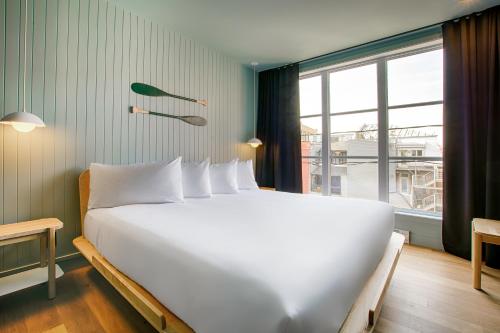 a large white bed in a room with a window at Les Lofts Dorchester - Par Les Lofts Vieux-Québec in Quebec City