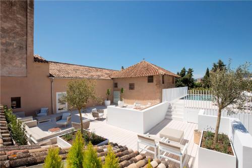 an outdoor patio with white furniture and trees at Convent de la Missio - Grand Luxury Boutique hotel, Adults Only in Palma de Mallorca