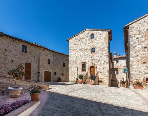 einen Innenhof eines Gebäudes mit zwei Steingebäuden in der Unterkunft Borgo Petroro in Todi