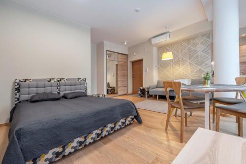 een slaapkamer met een bed en een eetkamer bij Eva R Apartments in Druskininkai