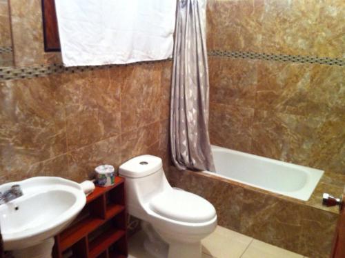 a bathroom with a toilet and a sink and a tub at Sosua Suites Condos in Sosúa