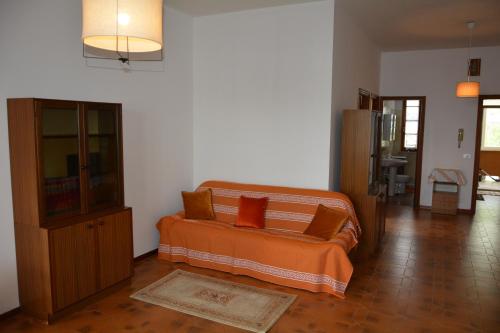 Sala de estar con cama con sábanas de color naranja en Appartamento AL 30, en Marzocca di Senigallia