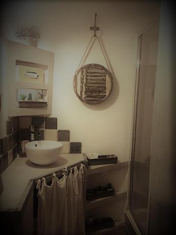 une salle de bain avec un lavabo et un miroir au mur dans l'établissement CHARME RAMATUELLE, à Ramatuelle